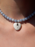 Necklace with a heart-shaped pendant on a person's neck