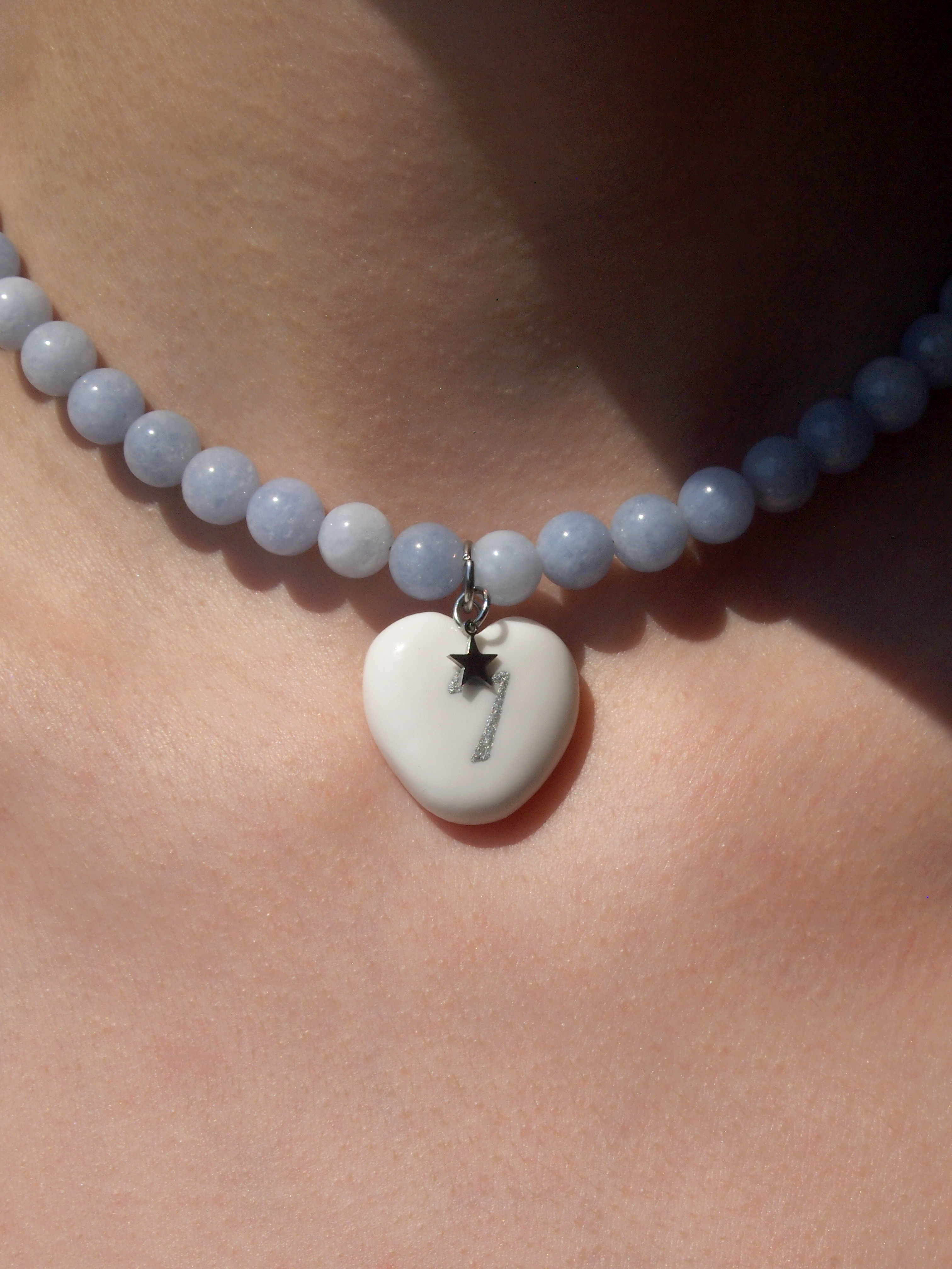Necklace with a heart-shaped pendant on a person's neck
