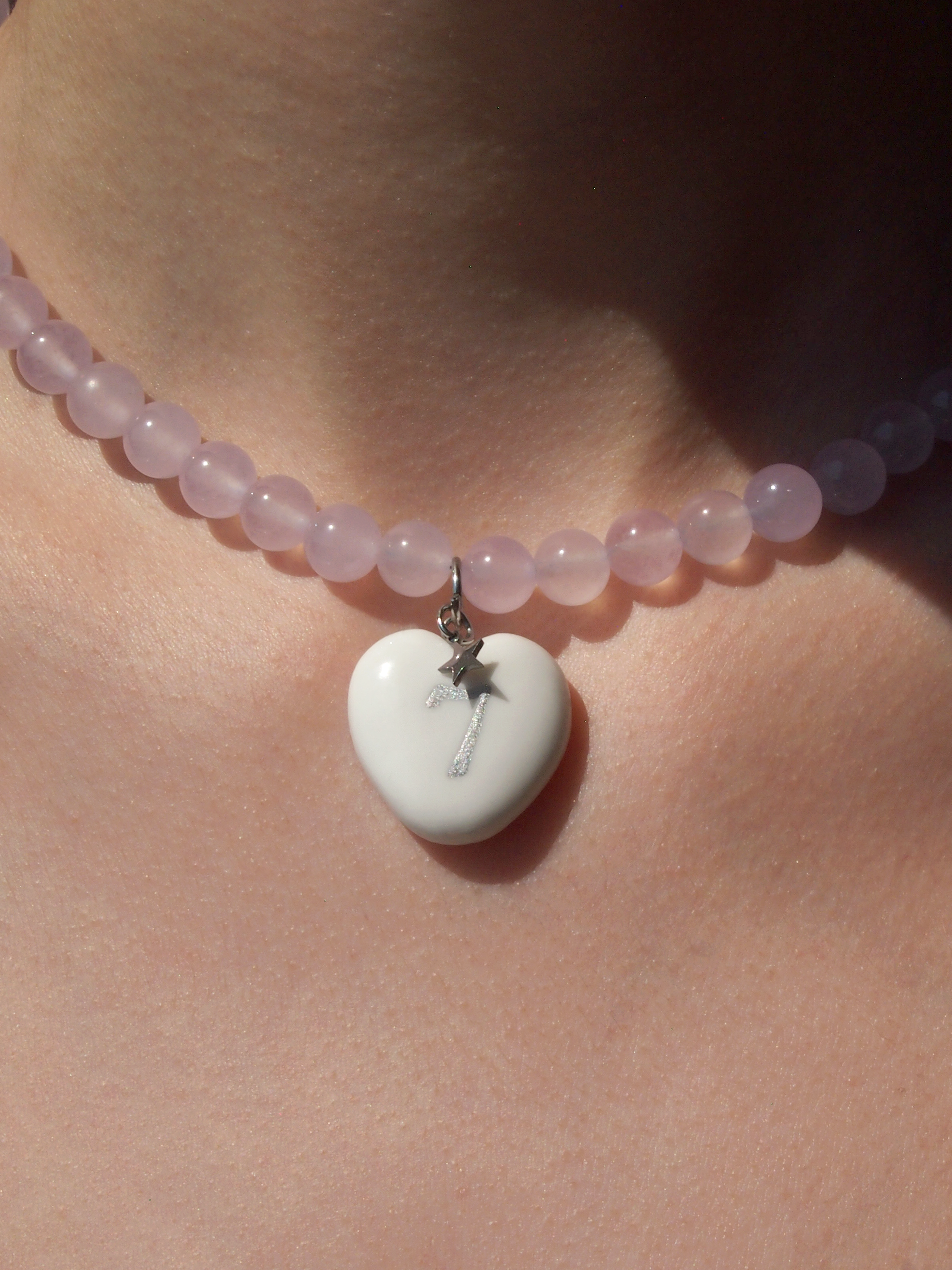 Necklace with a heart-shaped pendant on a person's neck